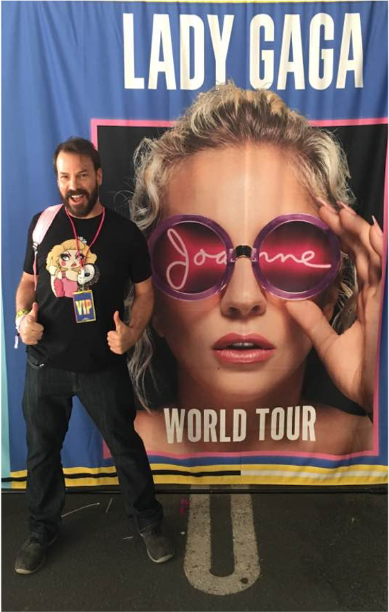 Video production - Wayne Hammett stands in front of a Lady Gaga tour banner